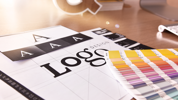 Arbeitsmaterialien für Logodesign mit Farbfächer und Typografie-Mustern.